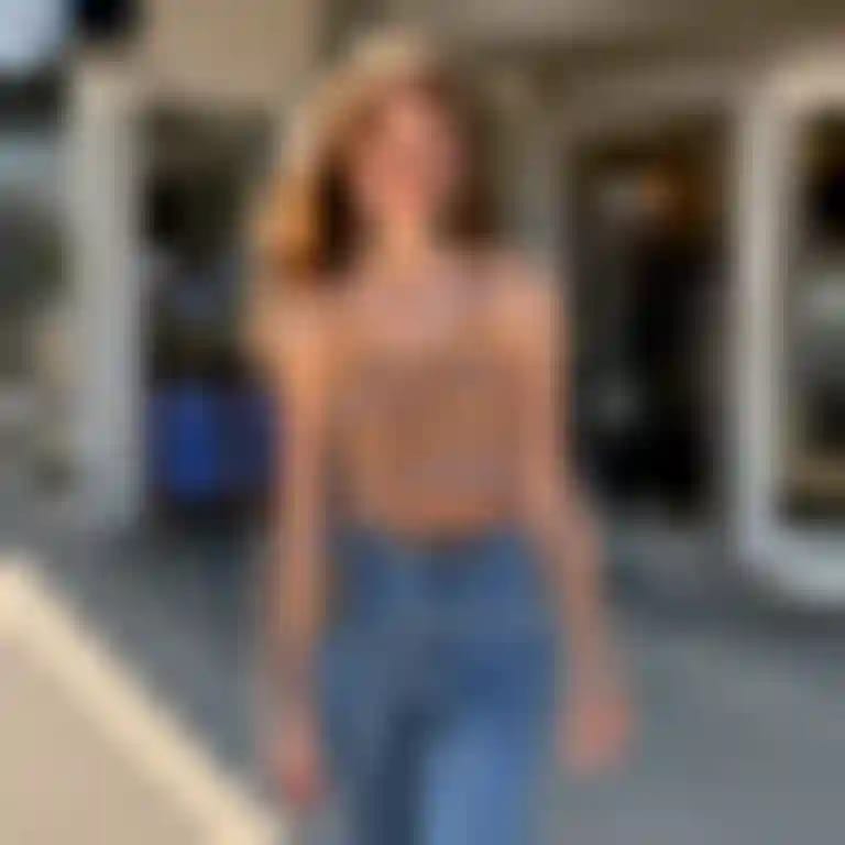Una donna in canottiera a righe e jeans cammina con sicurezza fuori da un negozio.