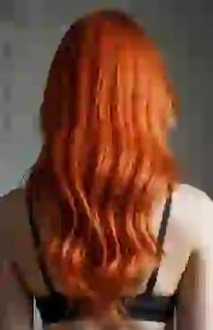 주황색 웨이브 머리를 한 여성의 뒷모습. AI 이미지 생성기의 머리 색깔 옵션입니다.
