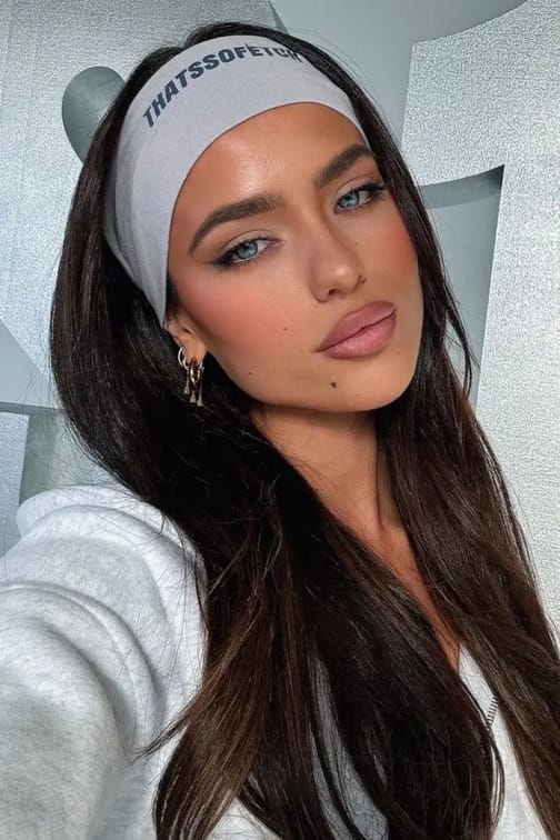 Woman in grey casual sports outsit posing confidently.